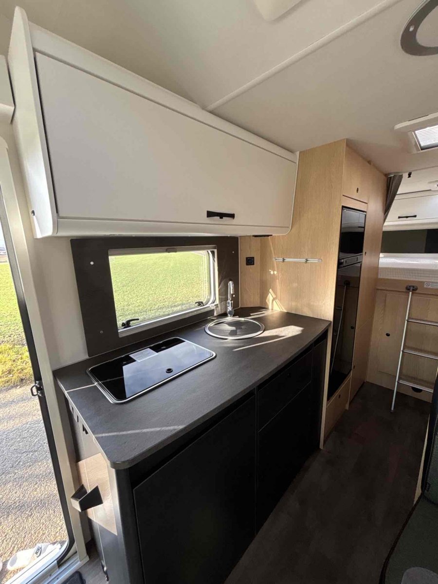 Küchenzeile im Wohnmobil mit Spüle, Kochfeld und Stauraum